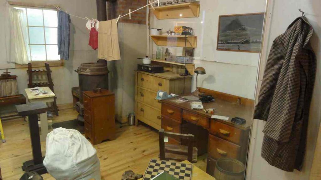 Half of a barracks space is a glassed-in artifact display, filled with furniture, clothes, and housewares. 