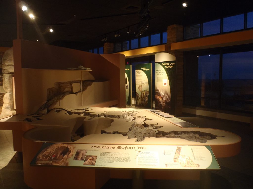 A large-scale model show the outline of the caverns. A scale replica of the visitor center sits at one end, with an elevator shaft reaching down. 