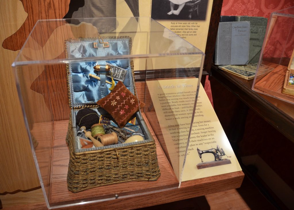 Artifact vitrines hold simple, well-used objects relating to the daily lives of immigrants. 