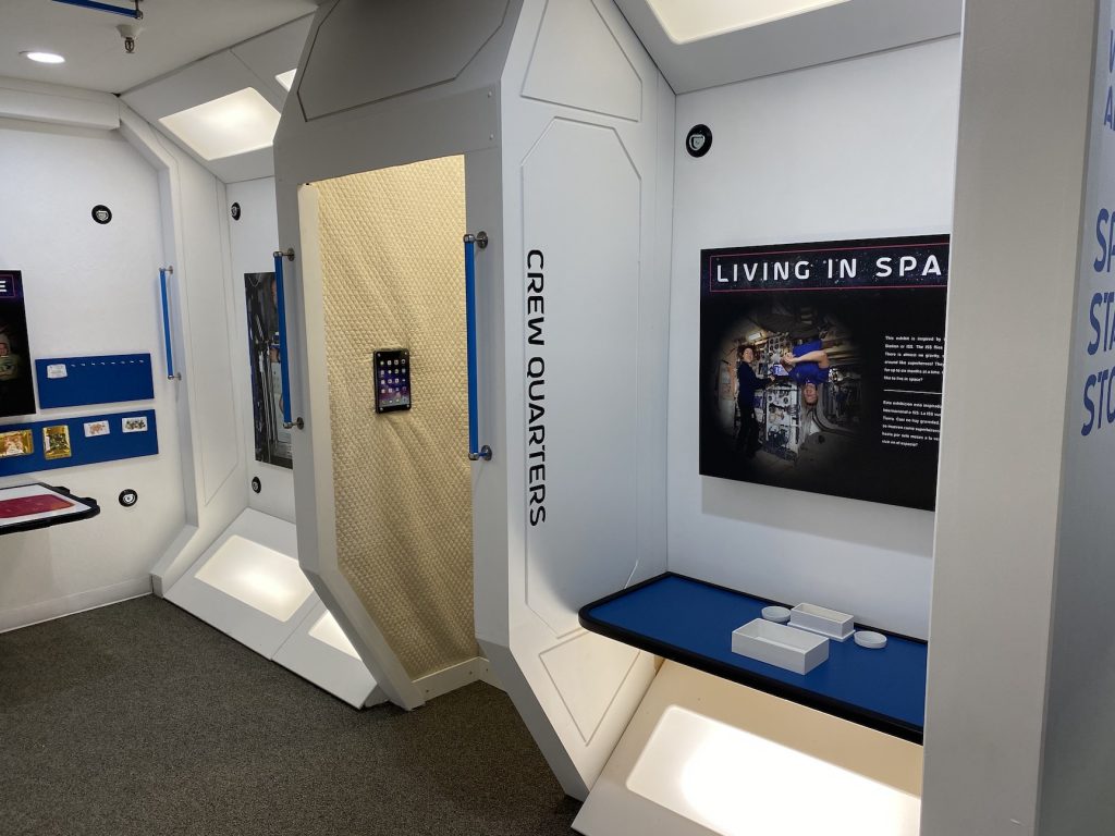 Inside a space station gallery, visitors can explore how astronauts live, eat, and sleep in low gravity. 